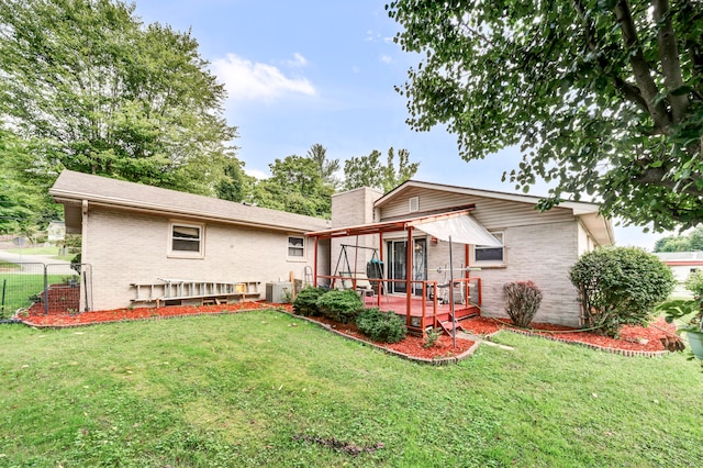 rear view of property with a deck and a lawn