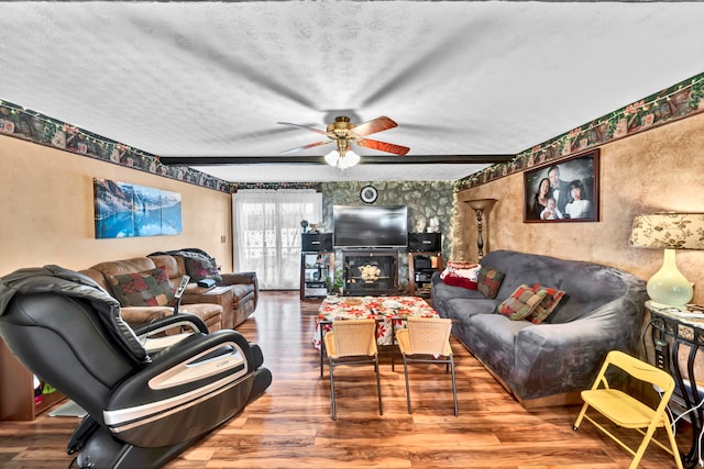 living room with hardwood / wood-style flooring, a textured ceiling, and ceiling fan