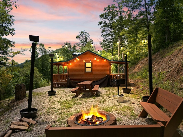 back house at dusk with an outdoor fire pit