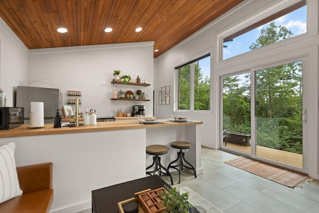 kitchen featuring wooden ceiling, ornamental molding, and light tile patterned floors