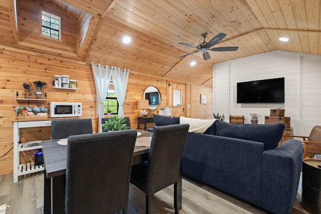 dining space featuring light hardwood / wood-style floors, wooden walls, and plenty of natural light