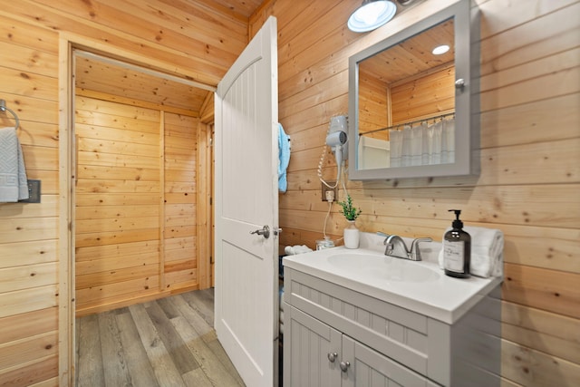 bathroom featuring wood finished floors, wood walls, vanity, and wood ceiling