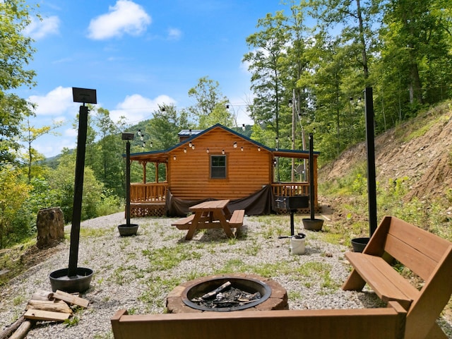 rear view of house featuring a deck and a fire pit