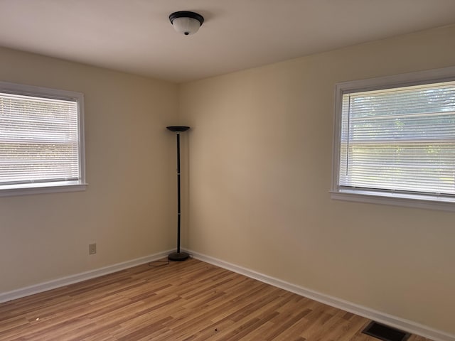 spare room with baseboards, visible vents, and light wood-type flooring