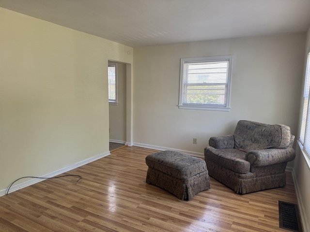 living area featuring light wood-style floors, visible vents, and a wealth of natural light