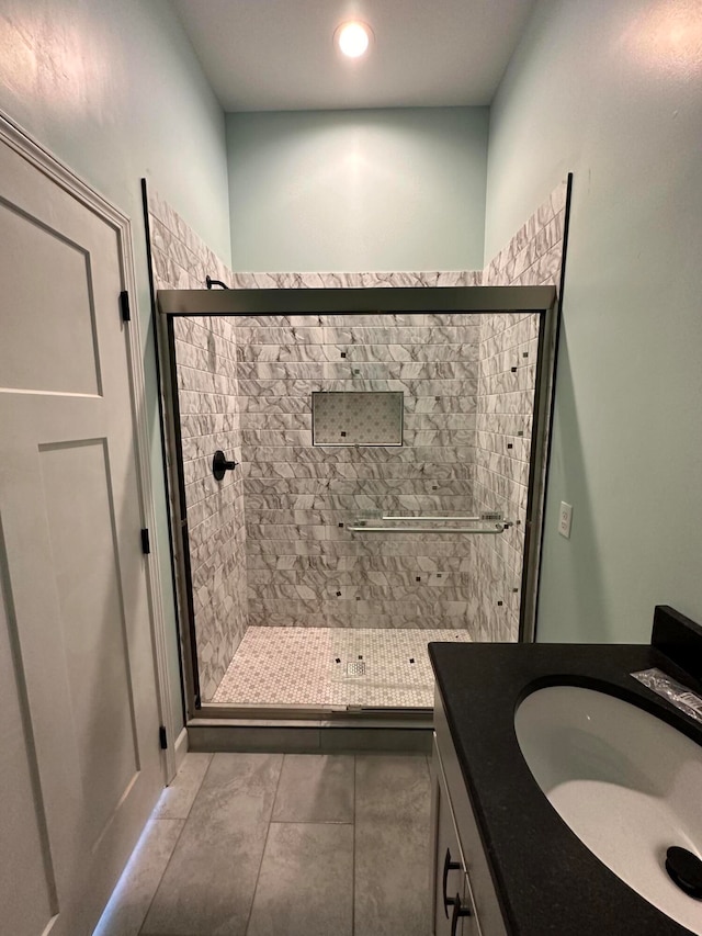 full bath featuring tile patterned flooring, a shower stall, and vanity