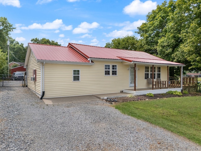 single story home with cooling unit, covered porch, and a front yard