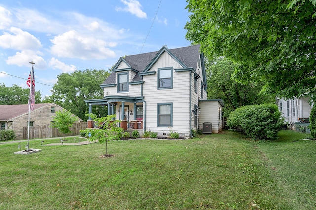 view of front of home featuring covered porch, central AC, and a front yard