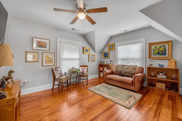 sitting room with vaulted ceiling, baseboards, visible vents, and light wood-style floors