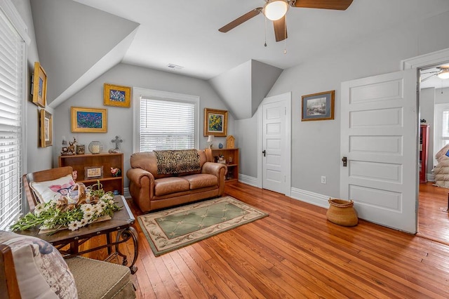 living room with light wood-style floors, lofted ceiling, visible vents, and ceiling fan