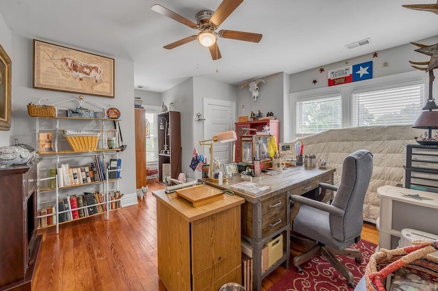 home office featuring a ceiling fan, visible vents, and dark wood-type flooring