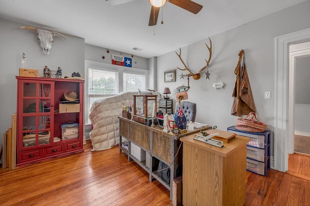 office space featuring visible vents, a ceiling fan, and wood finished floors