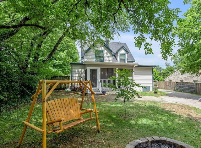 exterior space with a sunroom, fence, and a yard