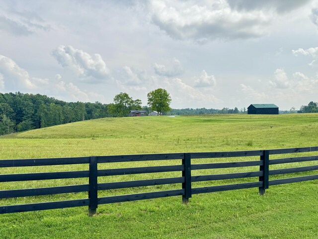 exterior space featuring a rural view and a yard