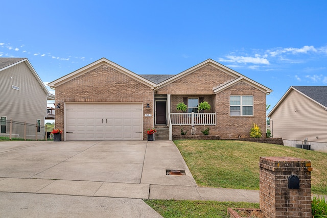 view of front of home with cooling unit, a garage, and a front lawn