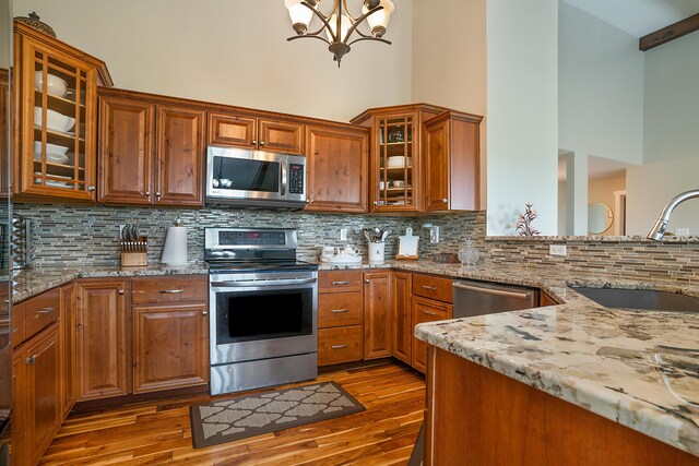 kitchen with tasteful backsplash, wood-type flooring, appliances with stainless steel finishes, and sink