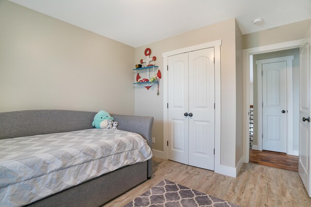 bedroom with light wood-type flooring and a closet