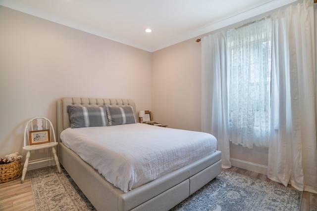 bedroom featuring light hardwood / wood-style floors and crown molding