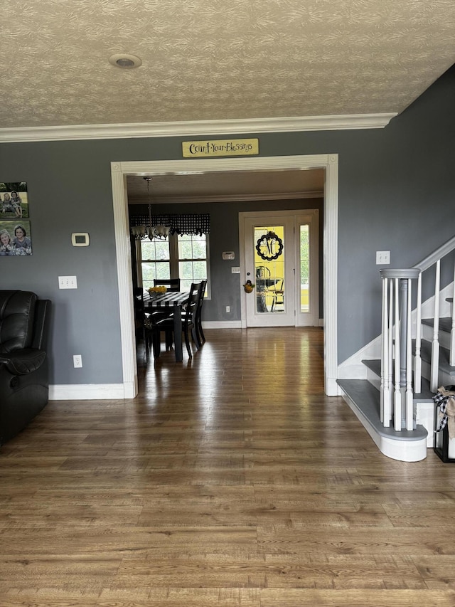 dining area featuring a notable chandelier, wood-type flooring, a textured ceiling, and ornamental molding