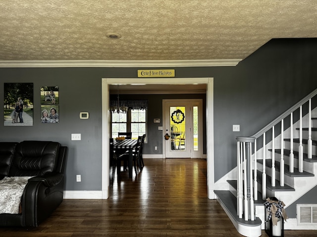 foyer entrance with crown molding, dark wood-type flooring, and a textured ceiling