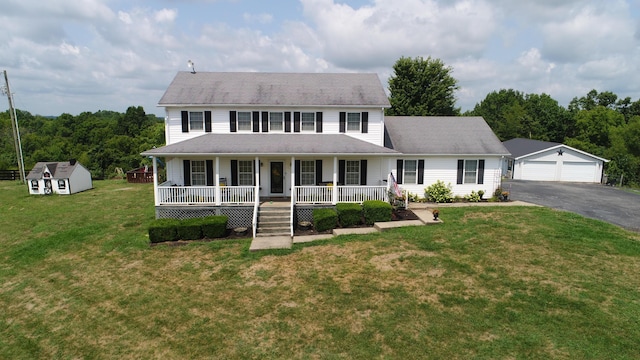 view of front facade with covered porch, a shed, a garage, and a front yard