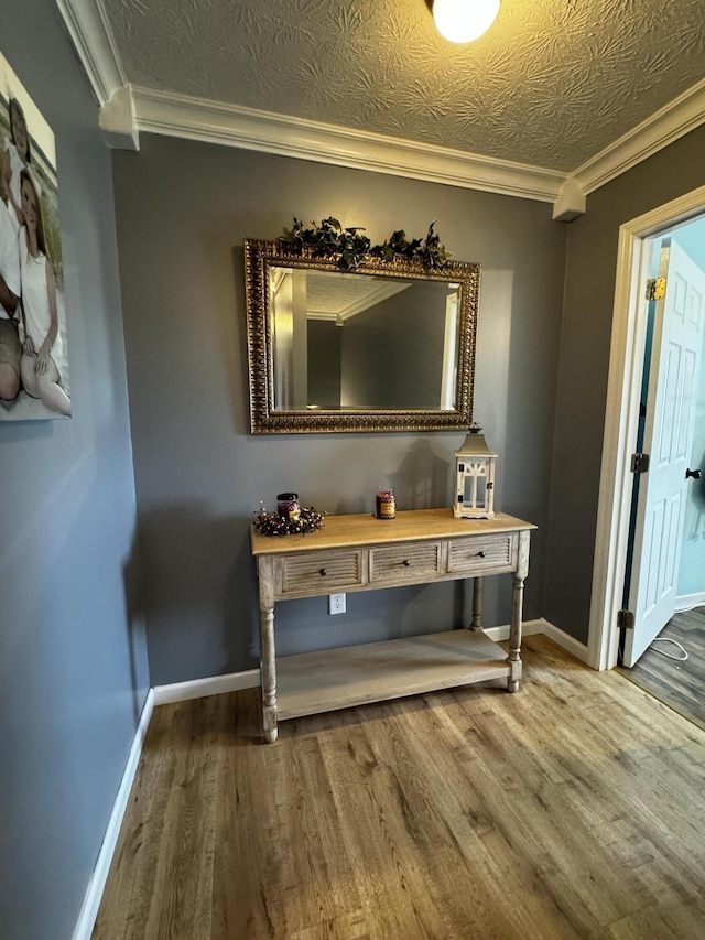 interior space featuring hardwood / wood-style floors, a textured ceiling, and crown molding