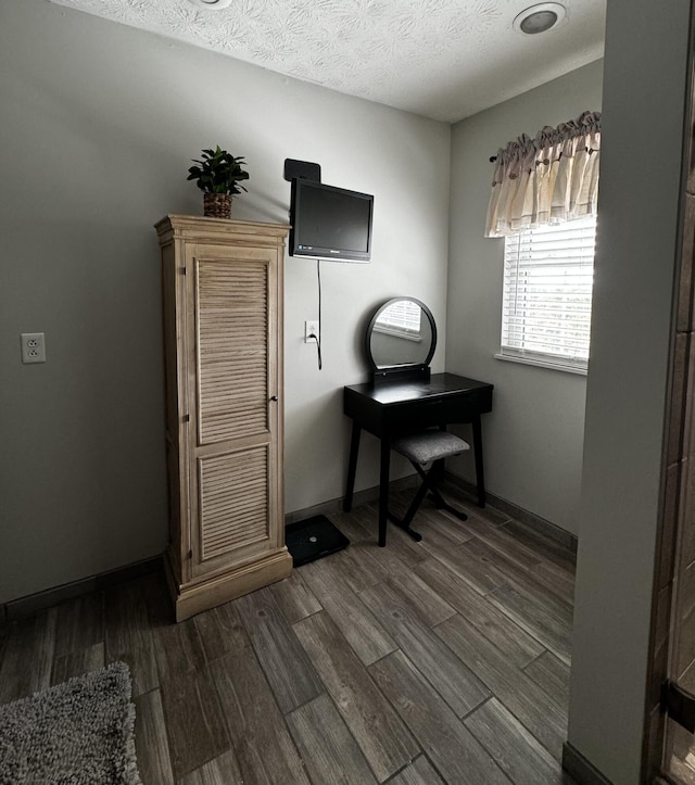 home office with dark hardwood / wood-style flooring and a textured ceiling