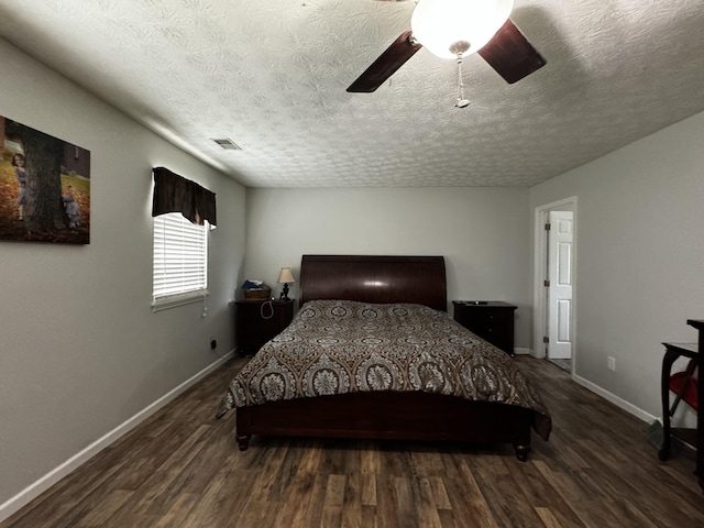 bedroom featuring ceiling fan, dark hardwood / wood-style flooring, and a textured ceiling