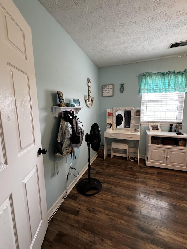 laundry room featuring a textured ceiling and dark hardwood / wood-style floors