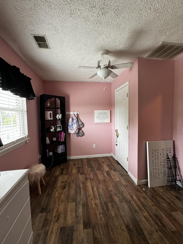 interior space with ceiling fan, dark hardwood / wood-style flooring, and a textured ceiling