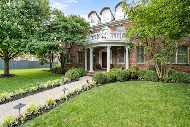 view of front of property with a balcony and a front lawn