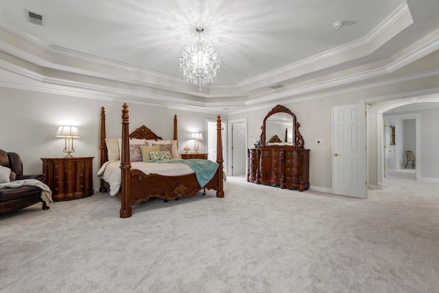 carpeted bedroom featuring ornamental molding, a chandelier, and a tray ceiling