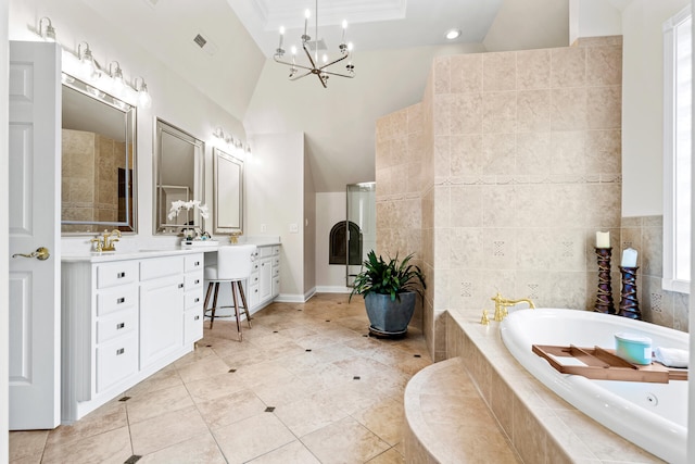 bathroom with tiled tub, vanity, high vaulted ceiling, an inviting chandelier, and tile patterned flooring