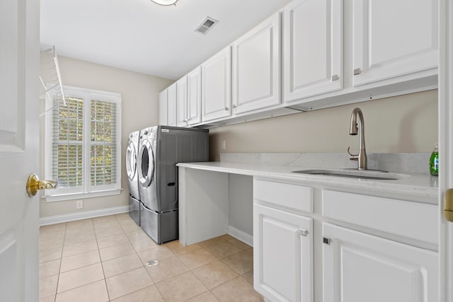 laundry room with sink, washer and dryer, cabinets, and light tile patterned floors