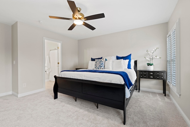 carpeted bedroom with multiple windows, ensuite bathroom, and ceiling fan