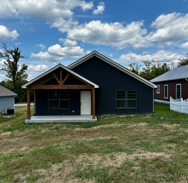 back of property with brick siding and a lawn