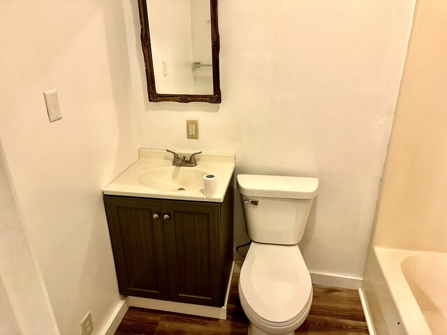 bathroom with vanity, toilet, and hardwood / wood-style floors