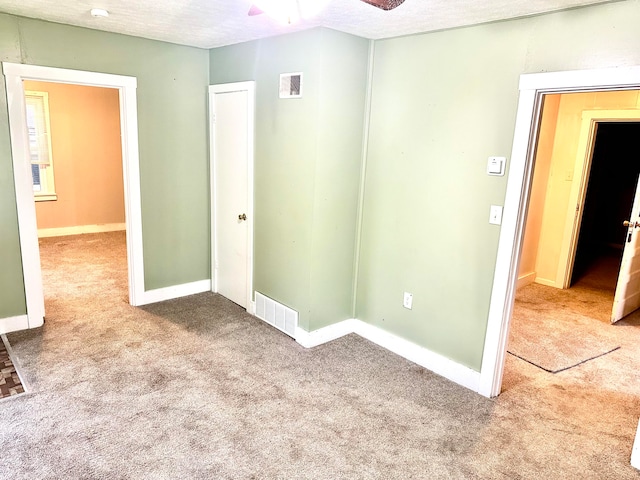 unfurnished room with carpet floors, a textured ceiling, and ceiling fan