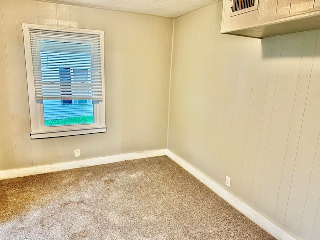 carpeted spare room with a textured ceiling