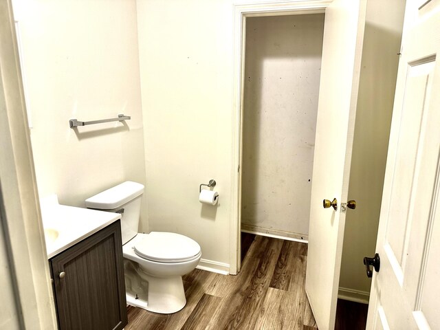 bathroom featuring wood-type flooring, toilet, and vanity