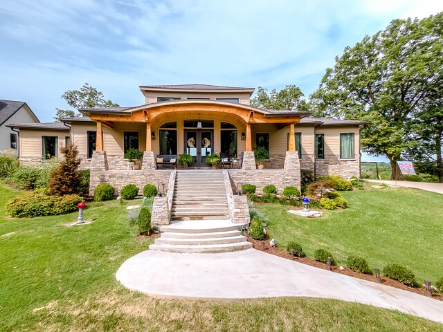 prairie-style house featuring covered porch and a front yard