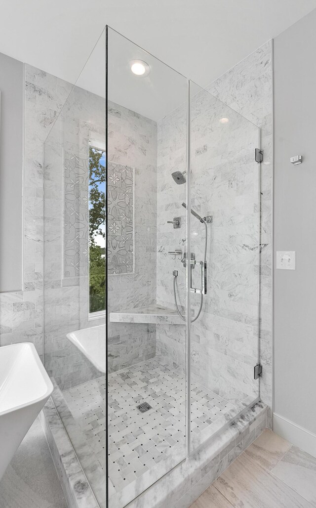 bathroom featuring tile patterned floors, separate shower and tub, and tile walls