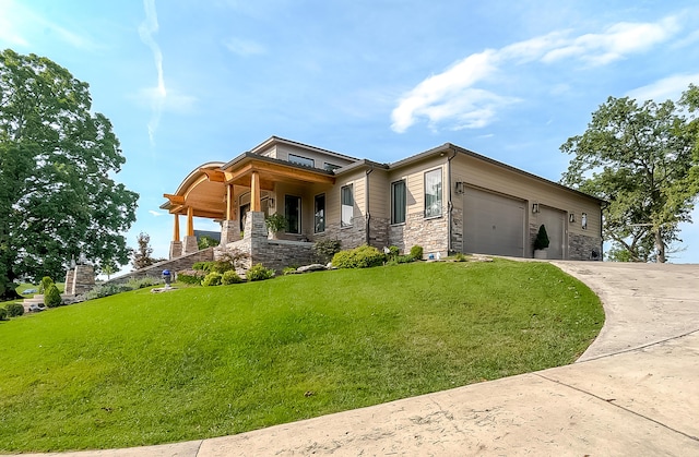 view of front facade featuring a garage, a front yard, and covered porch