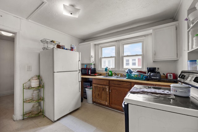 106 18th St, Corbin, KY 40701 - kitchen with white cabinetry, light tile patterned floors, white refrigerator, stove, and sink