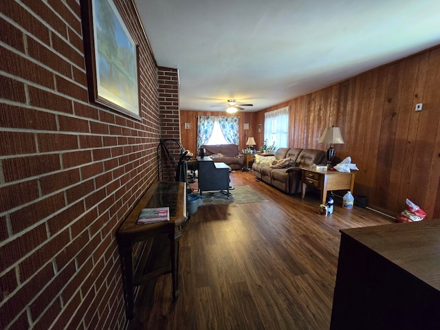 living room featuring brick wall, wood walls, ceiling fan, and wood-type flooring