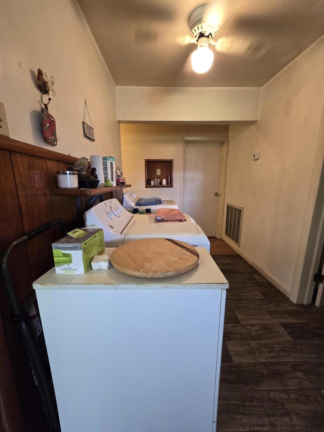 kitchen featuring dark hardwood / wood-style flooring, washer and clothes dryer, and ceiling fan