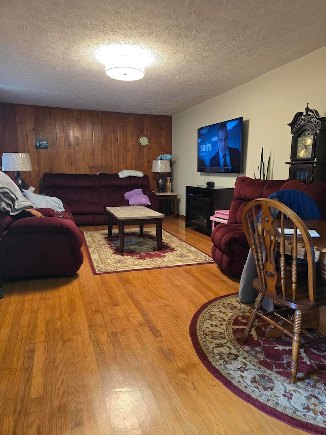 living room with light wood-type flooring and a textured ceiling