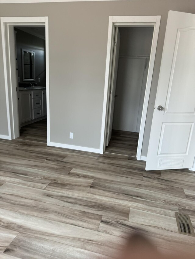 interior space with stainless steel electric range, ornamental molding, white cabinets, and light wood-type flooring