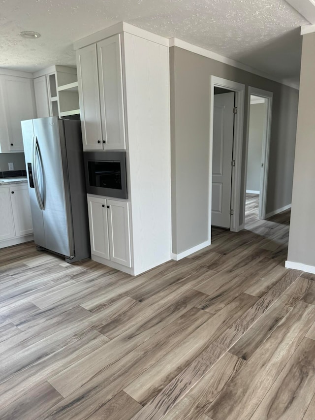 unfurnished living room featuring hardwood / wood-style floors, sink, and a textured ceiling