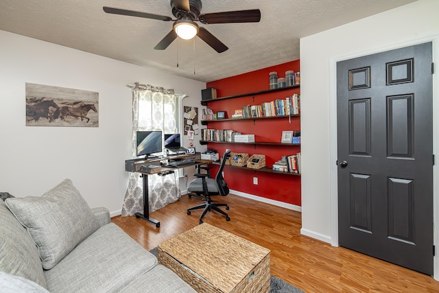 office area with ceiling fan, a textured ceiling, baseboards, and wood finished floors